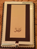 Decorative book with gold cover and Arabic text on a wooden surface