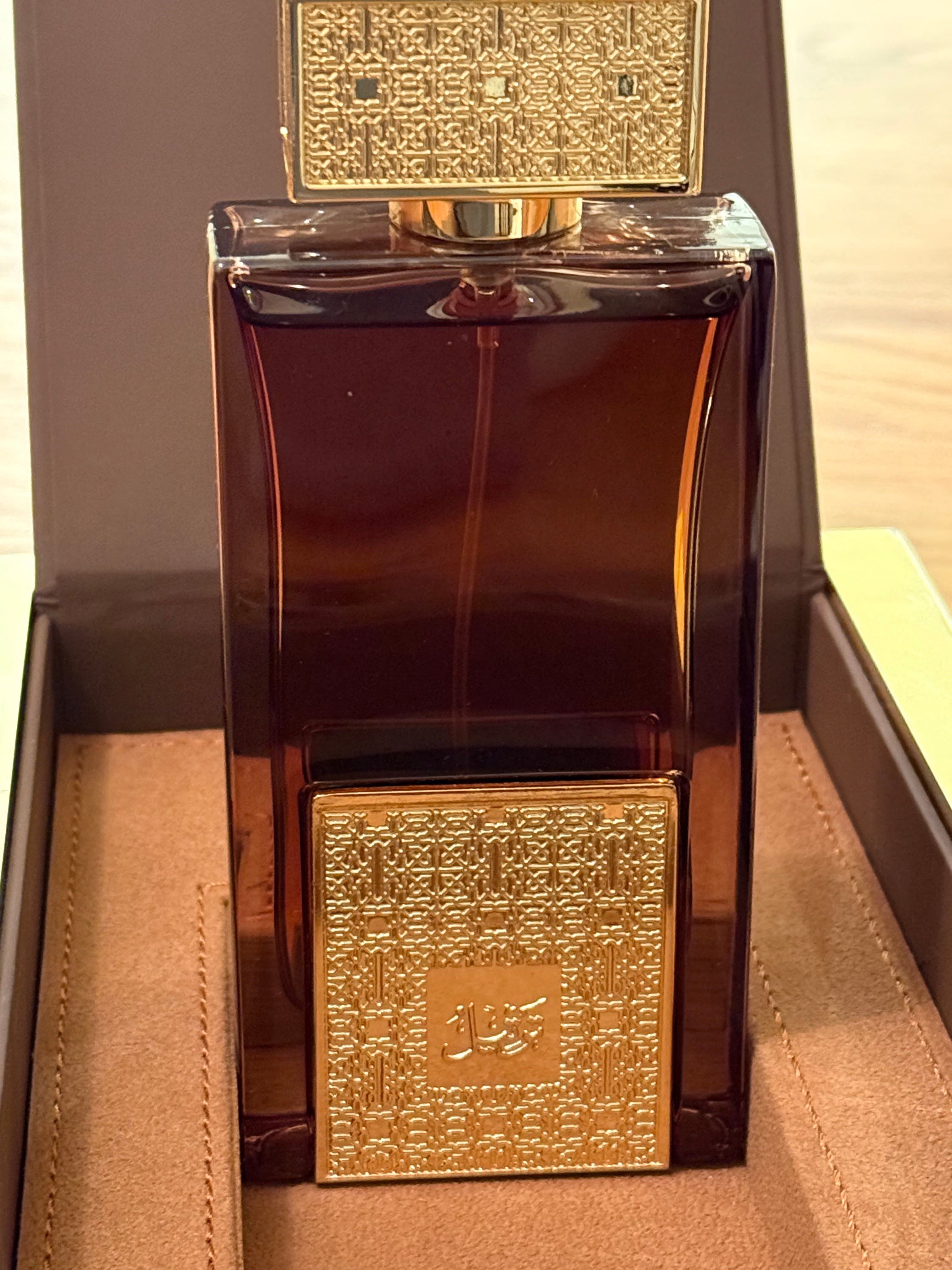 Luxurious brown and gold perfume bottle with intricate design