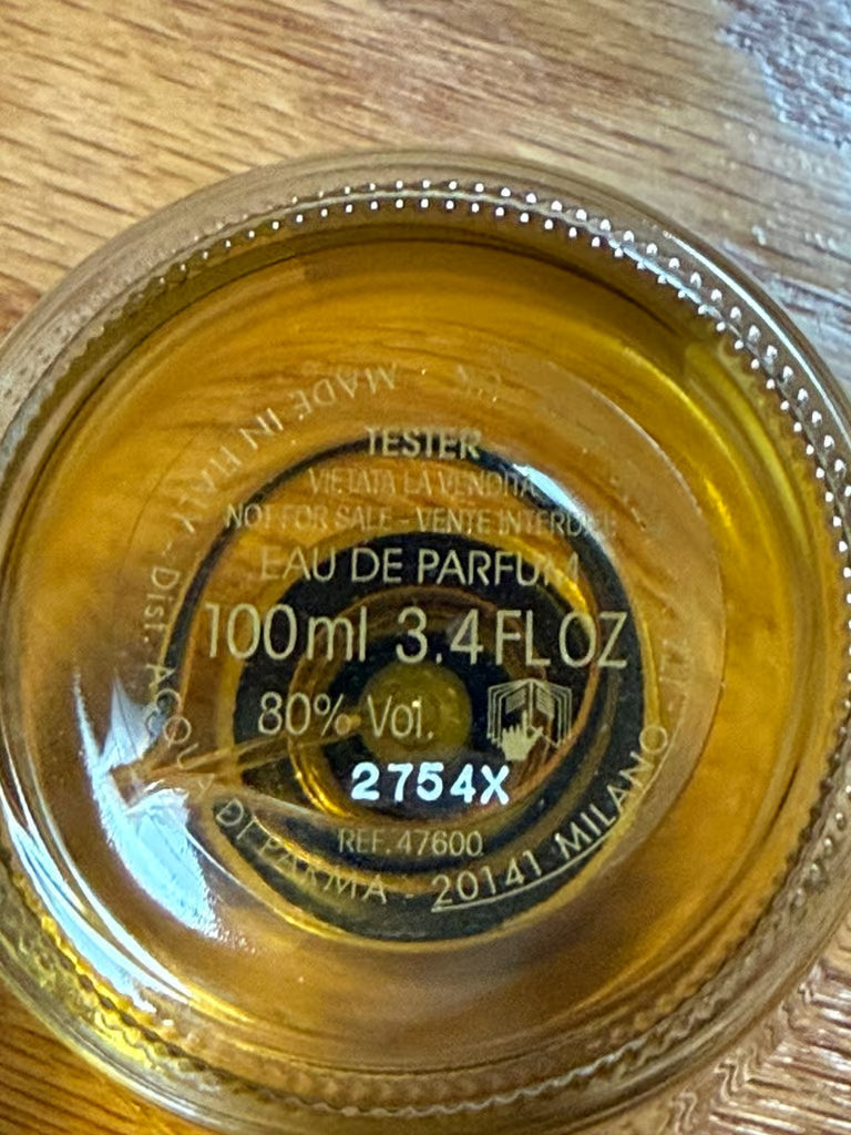 Close-up of a perfume bottle cap with branding and product details.
