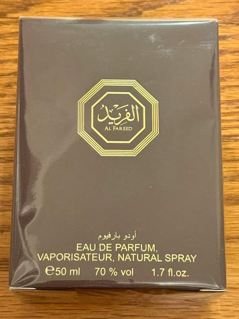 Al Fareed perfume packaging on a wooden surface